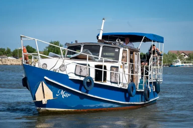 Barcă albastră pe canal navigabil în România.