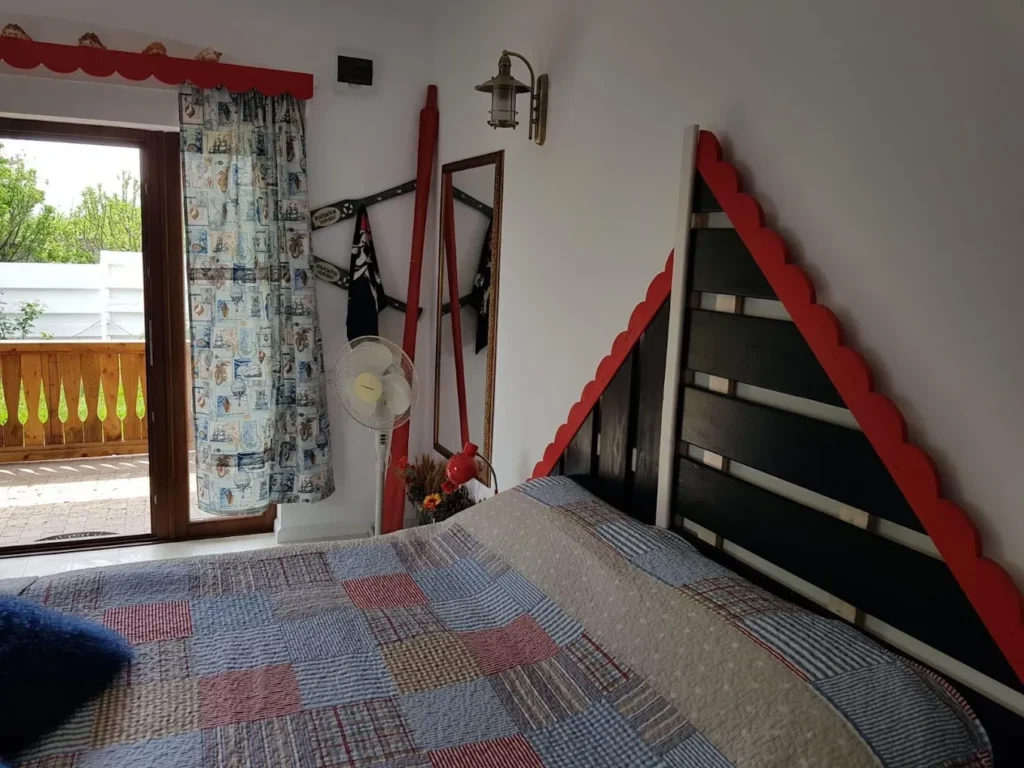 Dormitor rustic cu pat și balcon.