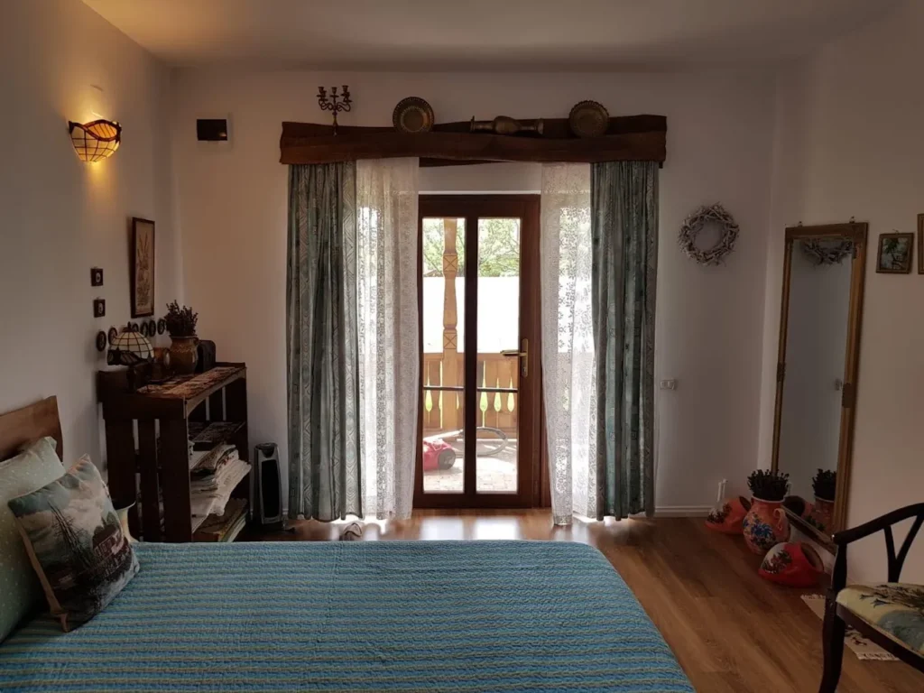 Cameră decorată cu pat, oglindă și draperii elegante.