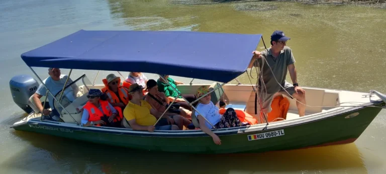 Grup de oameni într-o barcă pe apă.