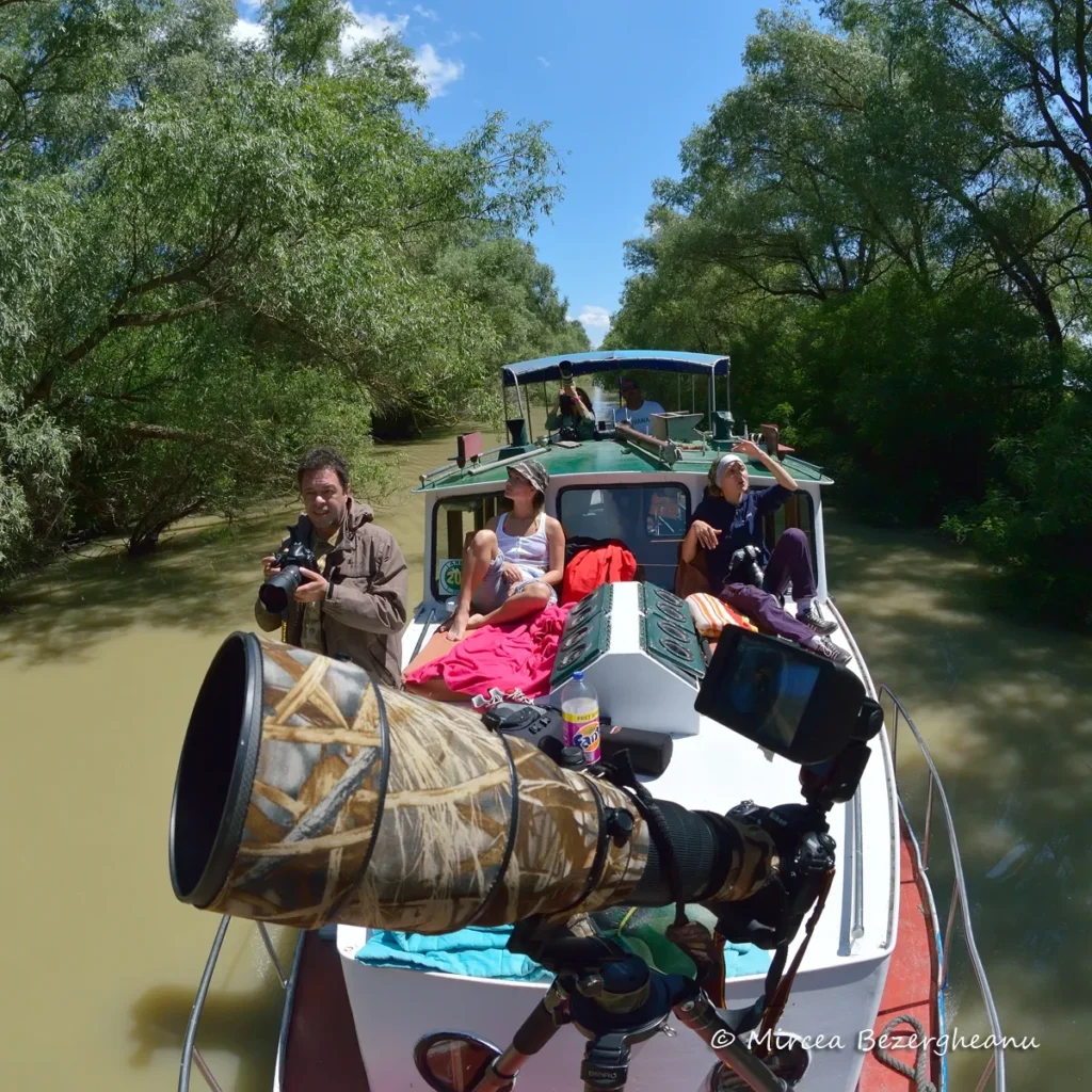 Fotografi plimbându-se cu barca prin Deltă, vară.